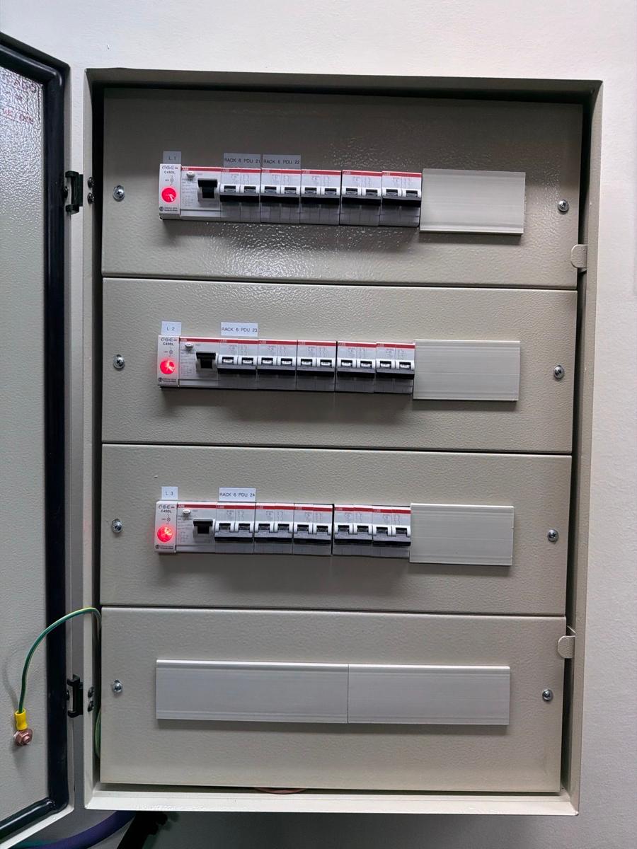 Tablero de distribución eléctrica abierto con varias filas de interruptores